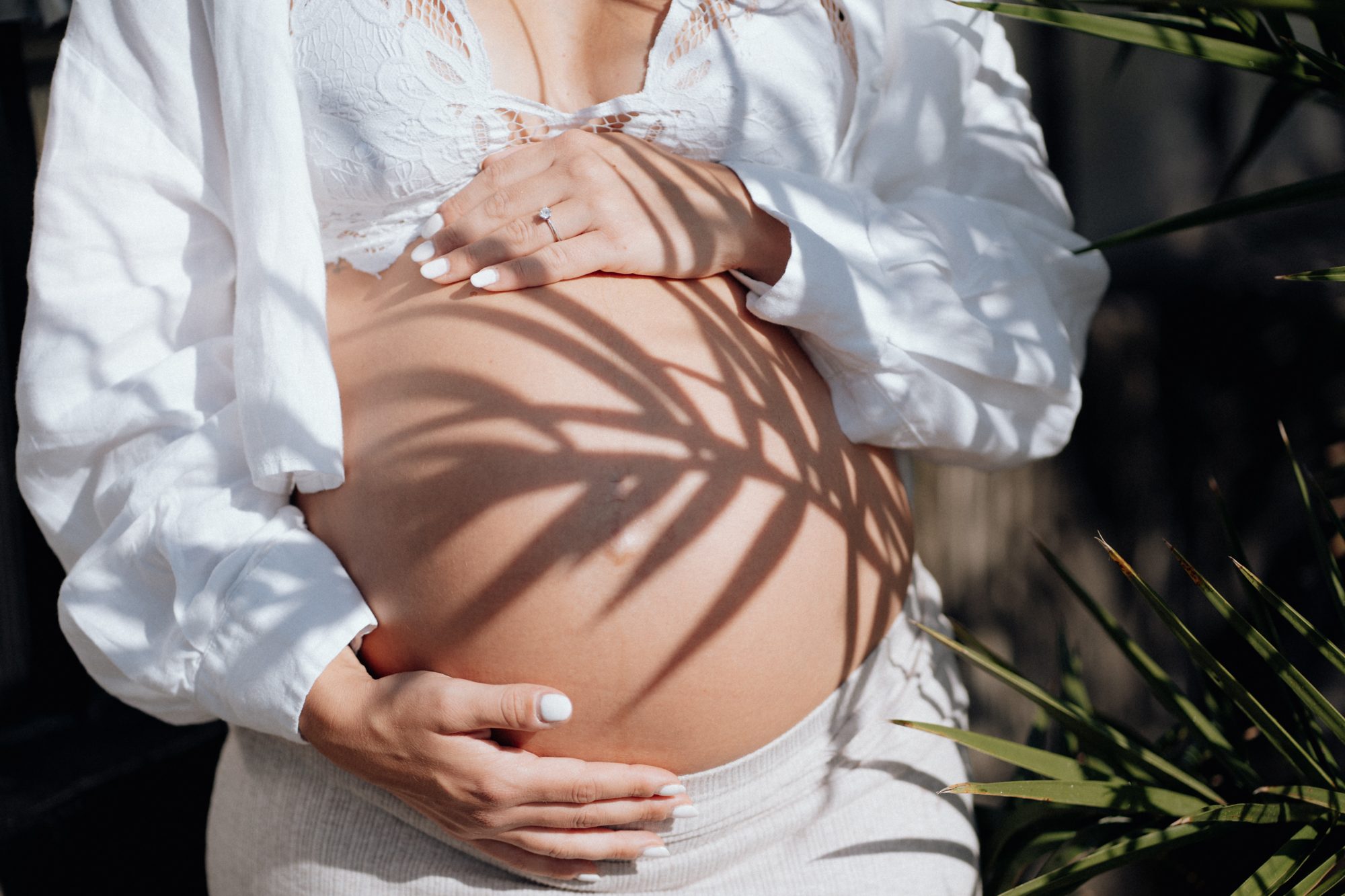 Babybauch mit Palmenschatten und Verlobungsring — Babybauchfotografie München