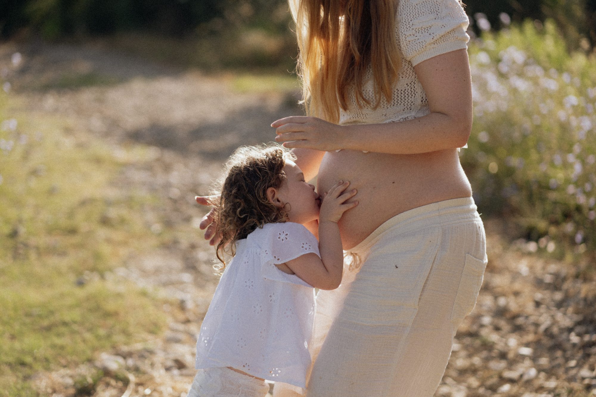 Kleinkind schmiegt sich an den Babybauch der Mutter — Familienfotografie