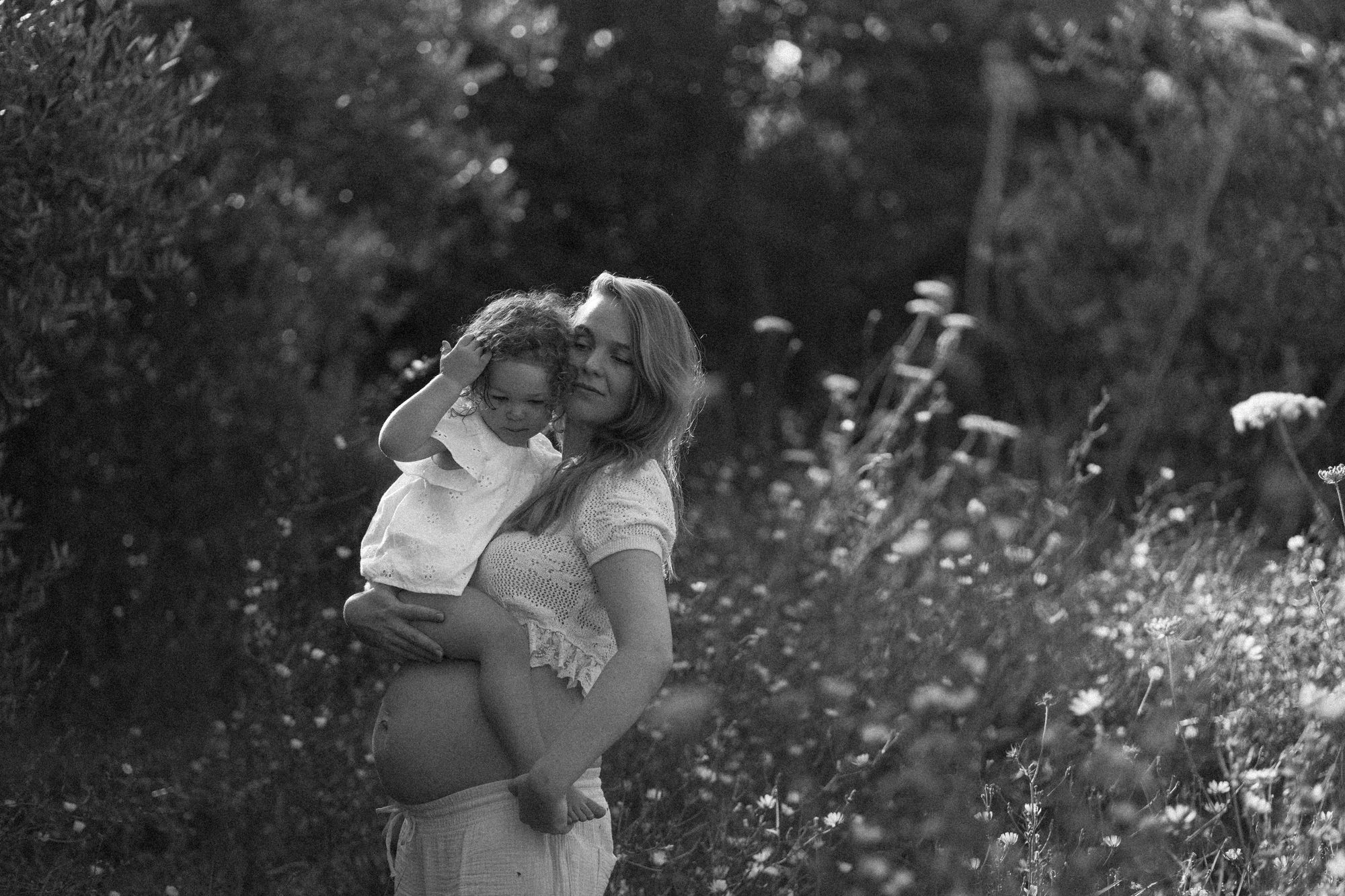 Mutter mit Kind in der Sommerwiese, schwarz-weiß — Familienfotografie