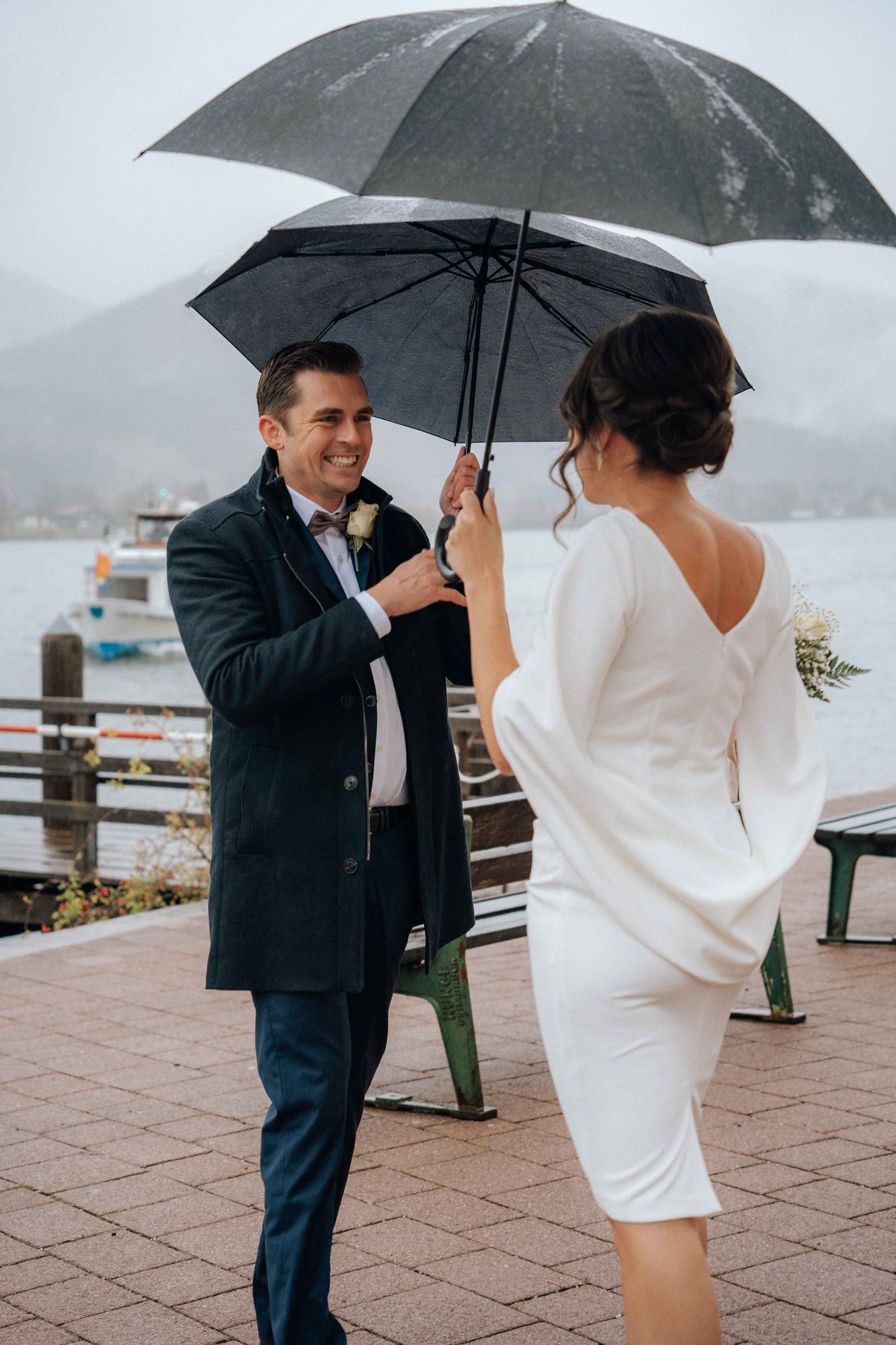 First Look im Regen — Bräutigam wartet mit Schirm am See